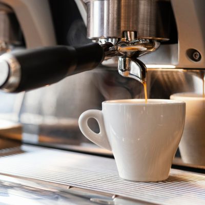 chiuda-sulla-macchina-che-versa-il-caffe-in-tazza_23-2148892834
